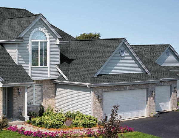 Brick front home with dark grey roof shingles.